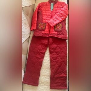 Orange quilted jacket with embroidered pockets and matching pants.